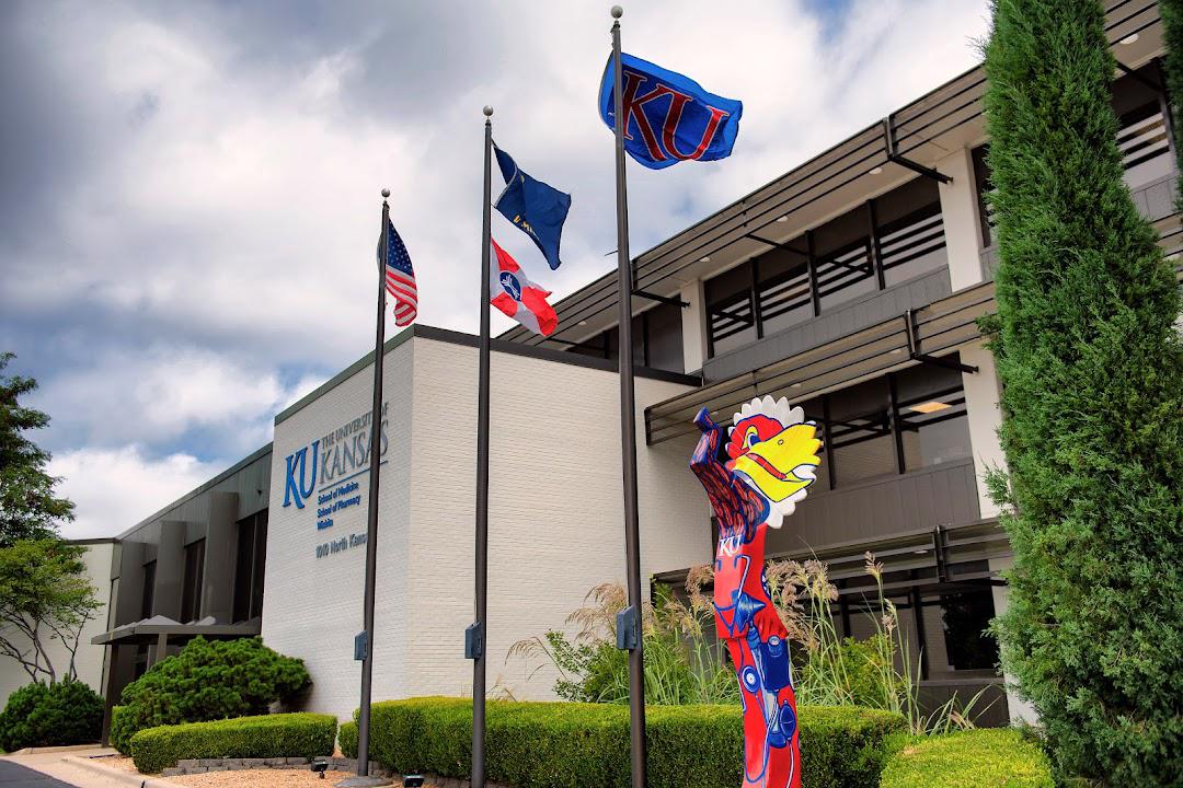 Outside picture of Wichita School of Medicine with 3 flag polls and a Jayhawk sculpture