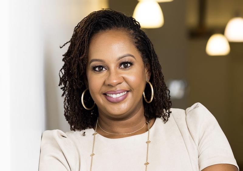 Image of Bridgette Jones wearing white top and gold necklace and gold earings