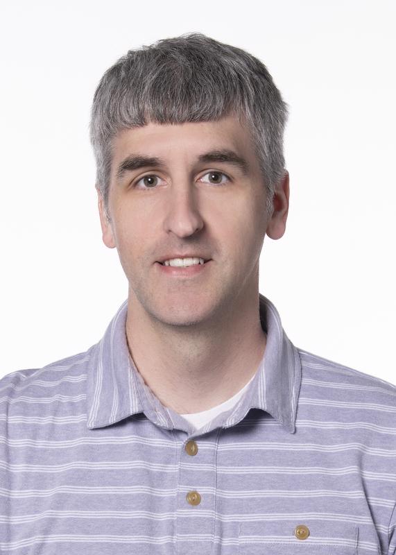 Image of Drew Fox wearing a purplish shirt with white stripes