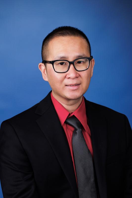 Hao Lou in red shirt with black tie wearing glasses
