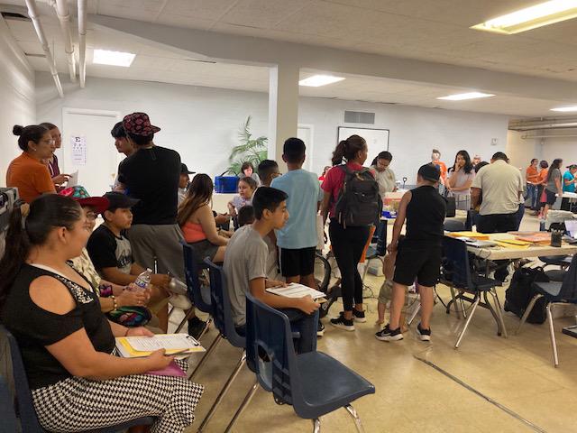 People sitting in chairs and some people standing in room