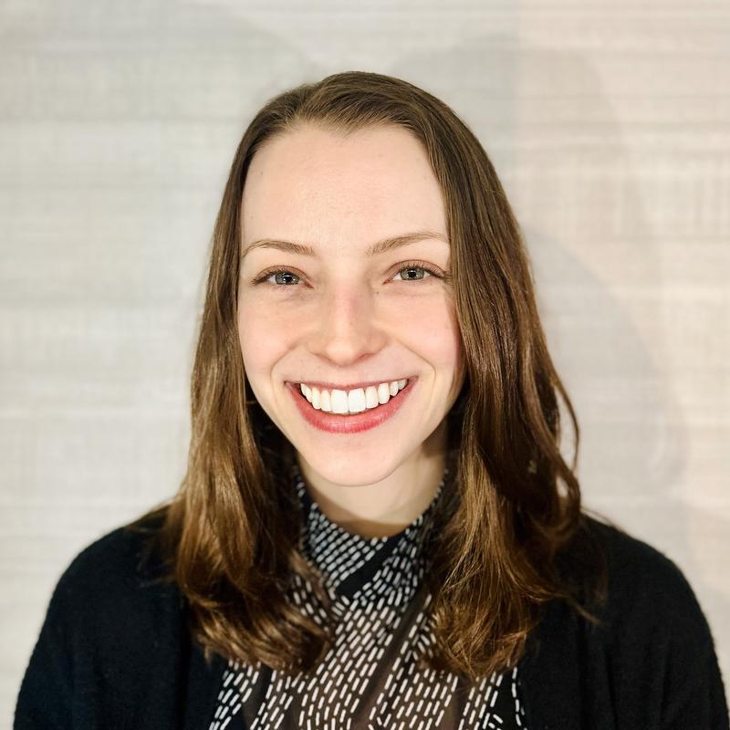 Smiling woman in black jacket and black and white top