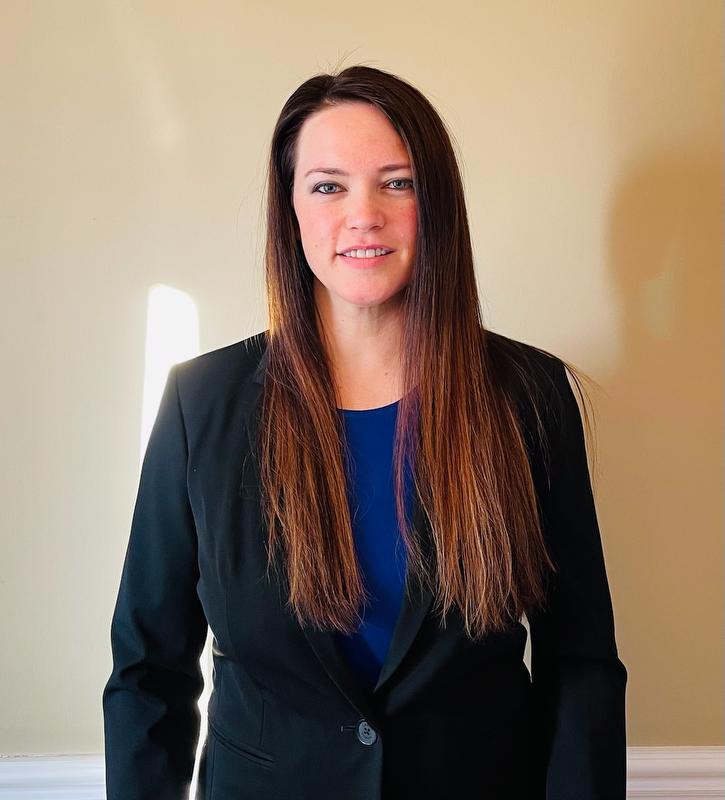 smiling woman wearing black jacket and blue shirt