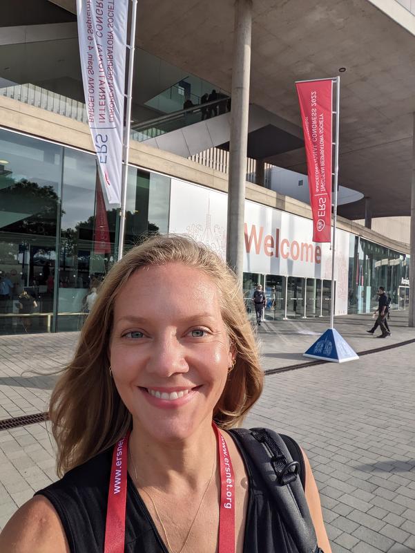 smiling woman with black top and red lanyard around her neck