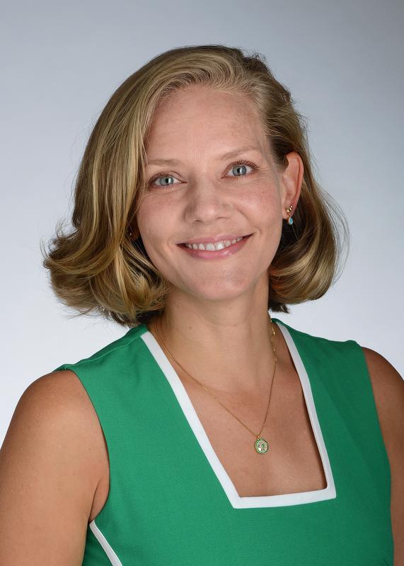 smiling woman wearing green shirt and a necklace