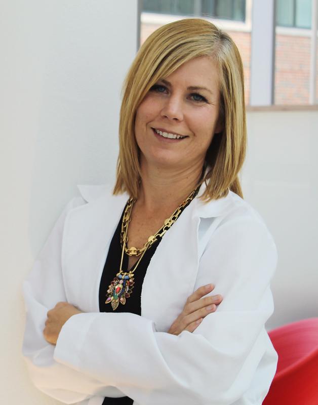 smiling woman in doctor jacket with gold necklaces