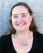 smiling woman in black shirt and large silver necklace