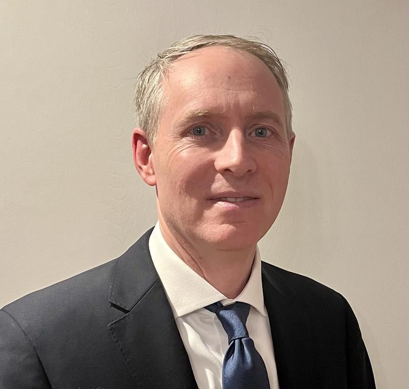 man in black jacket, white shirt and blue tie