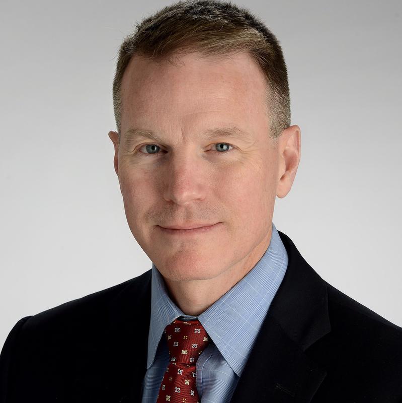 man in black jacket, blue shirt and red tie