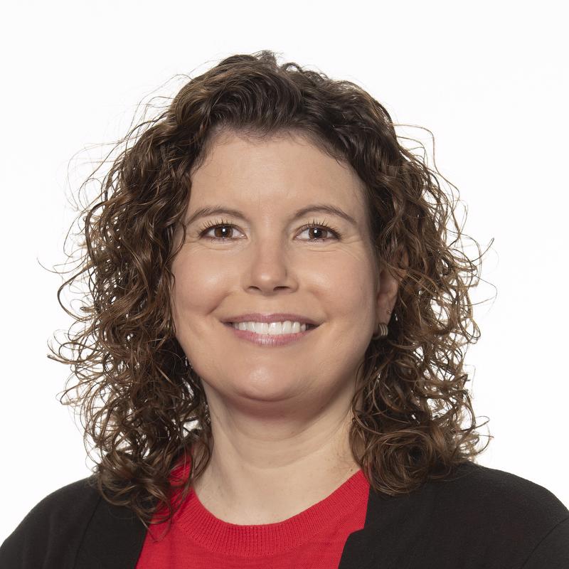smiling woman in red shirt and black jacket