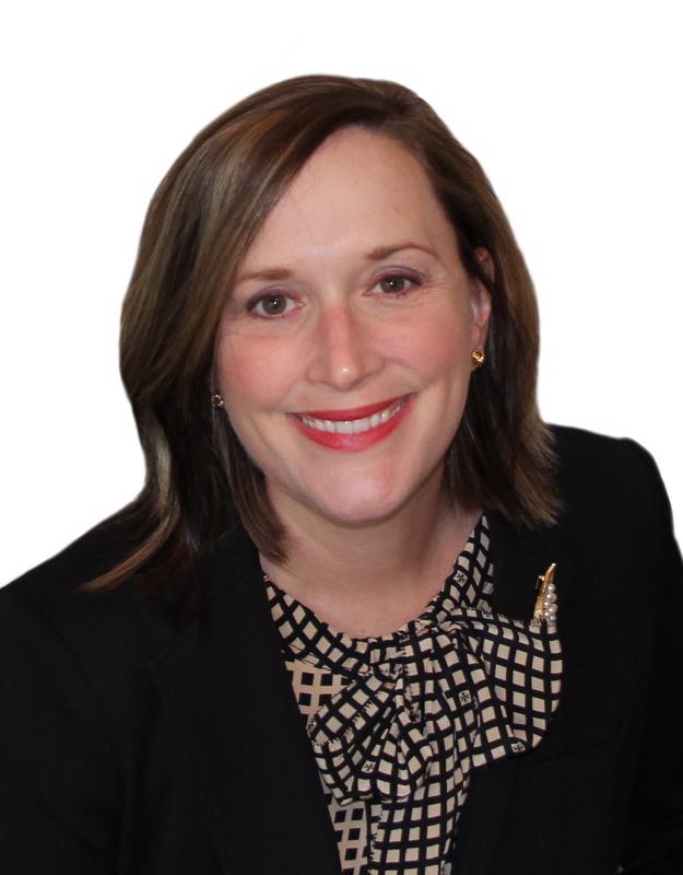 Smiling woman in black jacket and gold and black checked top with a bow