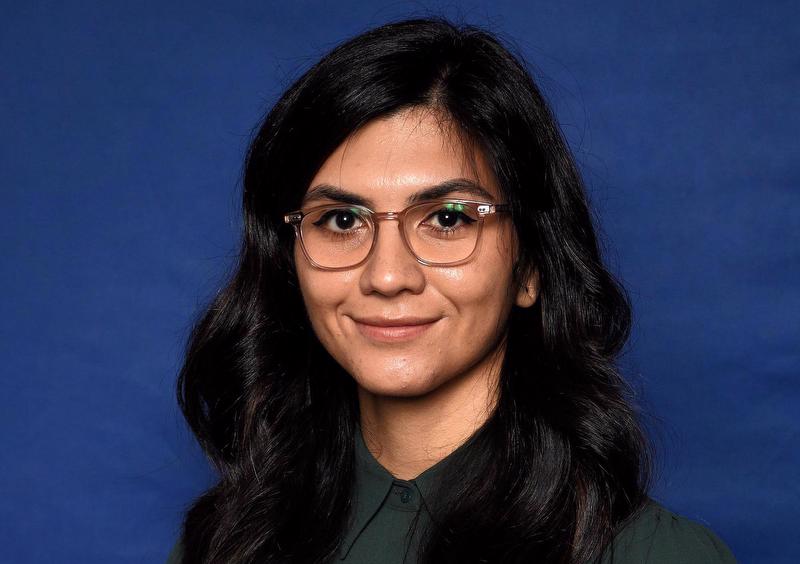 woman smiling  wearing green shirt and glasses
