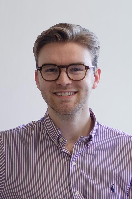 smiling man in red and white striped shirt wearing glasses