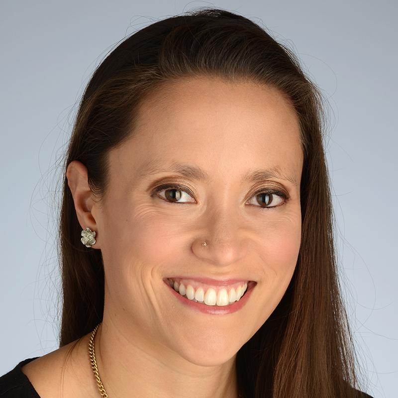Smiling woman with an earring, a nose ring and a gold necklace